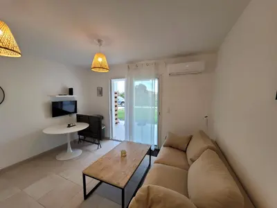 a living room with a couch and a table at Superbe appartement vue mer terrasse couverte face à la mer in Linguizzetta