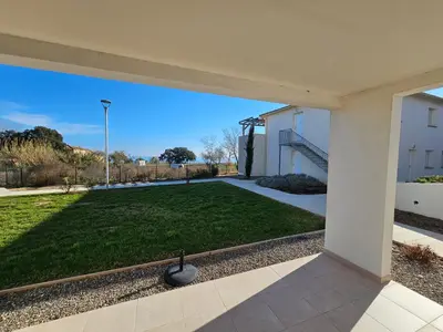 a view of a yard with a large lawn at Superbe appartement vue mer terrasse couverte face à la mer in Linguizzetta