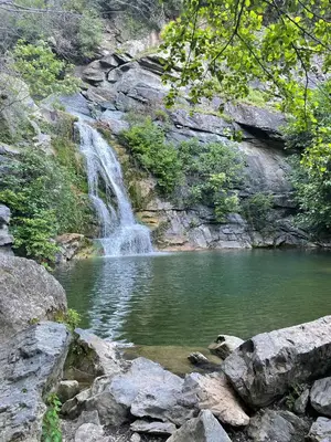 a waterfall in front of a pool of water at Chez Laurence et Fabien in Santa-Maria-Poggio