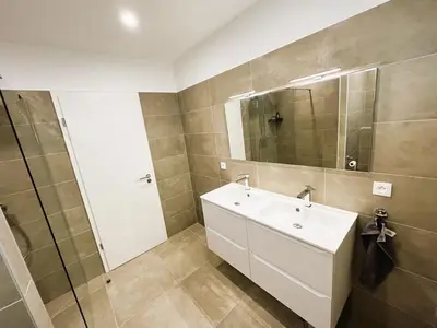 a bathroom with a white sink and a mirror at Villa Nasya, 8 pers, piscine chauffée, 5 mn plage voiture in Gialla