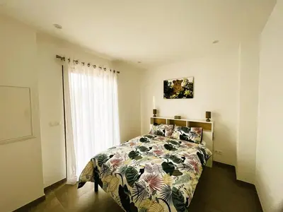 a bedroom with a bed with a floral bedspread at Villa Nasya, 8 pers, piscine chauffée, 5 mn plage voiture in Gialla