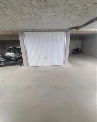 a garage with a large white garage door at Appartement dominant la baie d'Ajaccio in Ajaccio