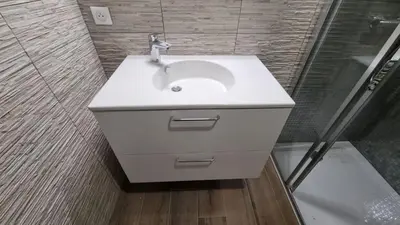a bathroom with a white sink and a shower at Appartement dominant la baie d'Ajaccio in Ajaccio