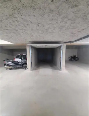 a garage with a car and a motorcycle parked in it at Appartement dominant la baie d'Ajaccio in Ajaccio