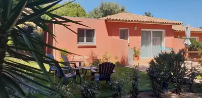 a house with a table and chairs in the yard at A VIGNA VECCHIA - CHARMANT 3 PIECES SUD PORTO VECCHIO in Porto-Vecchio