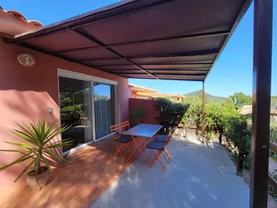 a patio with a table and chairs on a balcony at A VIGNA VECCHIA - CHARMANT 3 PIECES SUD PORTO VECCHIO in Porto-Vecchio