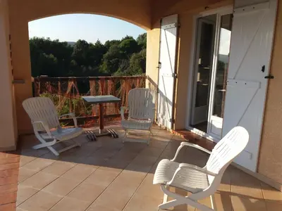 a patio with three chairs and a table on a balcony at villa marina in Sartène