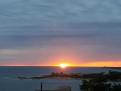 a sunset over an island in the ocean at villa marina in Sartène