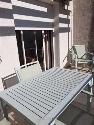 a table and two chairs on a balcony at Bel appartement avec piscine- Poggio Mezzana in Poggio-Mezzana