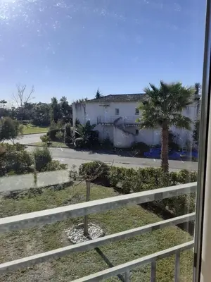 a view from a window of a street with a palm tree at Bel appartement avec piscine- Poggio Mezzana in Poggio-Mezzana