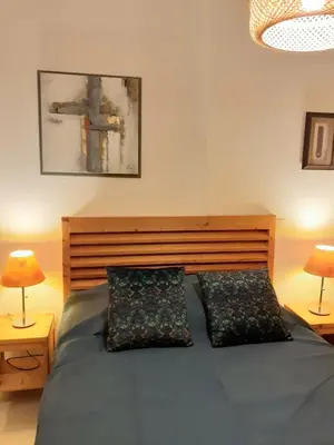 a bedroom with a bed with two pillows and two lamps at Bel appartement avec piscine- Poggio Mezzana in Poggio-Mezzana