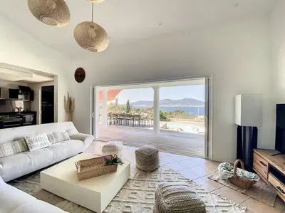 a living room with a white couch and a large window at Luxury Villa with Stunning Panoramic Views in Grosseto-Prugna