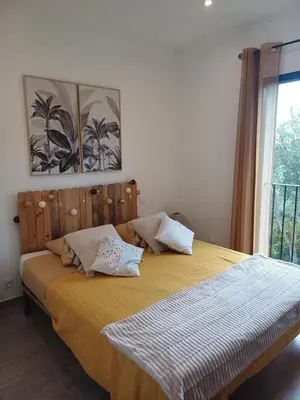 a bedroom with a bed with yellow sheets and a window at VILLA I BAGHI - sans vis-à-vis au calme in Sainte-Lucie de Porto-Vecchio