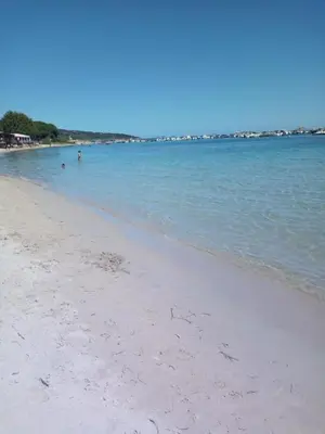 a beach with people swimming in the water at VILLA I BAGHI - sans vis-à-vis au calme in Sainte-Lucie de Porto-Vecchio
