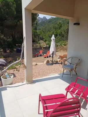 a patio with chairs and a table and an umbrella at VILLA I BAGHI - sans vis-à-vis au calme in Sainte-Lucie de Porto-Vecchio