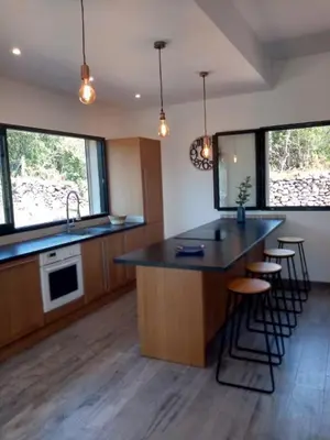 a kitchen with a large island with bar stools at VILLA I BAGHI - sans vis-à-vis au calme in Sainte-Lucie de Porto-Vecchio
