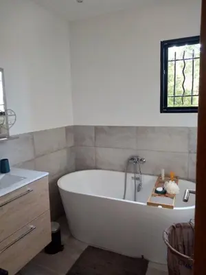 a bathroom with a white tub and a window at VILLA I BAGHI - sans vis-à-vis au calme in Sainte-Lucie de Porto-Vecchio