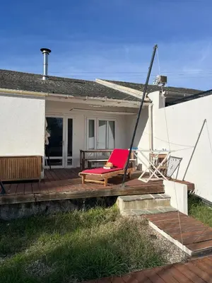 a red chair sitting on a deck next to a house at Helles freundliche Ferienhaus für Naturisten FKK auf Korsika in Linguizzetta