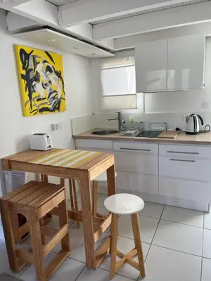 a kitchen with a wooden table and stool in it at Helles freundliche Ferienhaus für Naturisten FKK auf Korsika in Linguizzetta