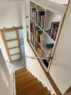 a staircase with white bookshelves in a house at Helles freundliche Ferienhaus für Naturisten FKK auf Korsika in Linguizzetta