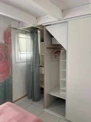 a bedroom with a closet with a glass door at Helles freundliche Ferienhaus für Naturisten FKK auf Korsika in Linguizzetta