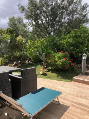 a patio with a table and chairs and flowers at Cap Martin. in Lecci