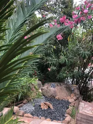 a garden with a rock and some plants and flowers at Cap Martin. in Lecci