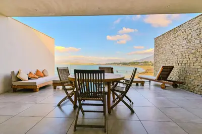 a dining room with a view of the water at Le Galatée, T3 luxe in Porticcio