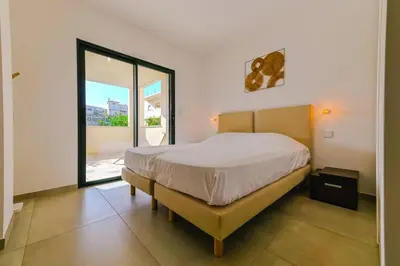 a bedroom with a bed and a large window at Le Galatée, T3 luxe in Porticcio