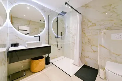 a bathroom with a sink and a mirror at Le Galatée, T3 luxe in Porticcio