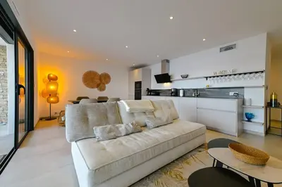 a living room with a couch and a kitchen at Le Galatée, T3 luxe in Porticcio
