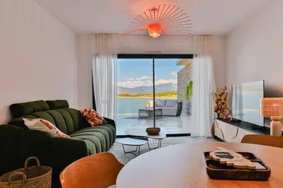 a living room with a green couch and a table at Le Galatée ,T2 luxe pieds dans l'eau in Porticcio