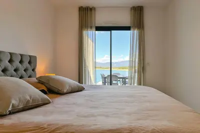 a bedroom with a large bed with a large window at Le Galatée ,T2 luxe pieds dans l'eau in Porticcio
