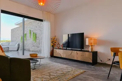 a living room with a flat screen tv and a couch at Le Galatée ,T2 luxe pieds dans l'eau in Porticcio