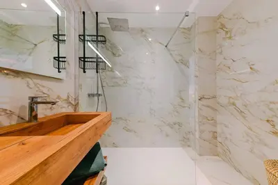 a bathroom with a shower and a wooden sink at Le Galatée ,T2 luxe pieds dans l'eau in Porticcio