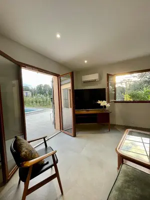 a living room with a tv and a chair and a table at Maison de campagne entre Ajaccio et Porticcio in Cauro