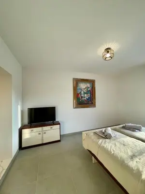 a bedroom with a bed and a flat screen tv at Maison de campagne entre Ajaccio et Porticcio in Cauro