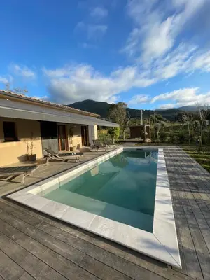 a swimming pool in a backyard with a house at Maison de campagne entre Ajaccio et Porticcio in Cauro