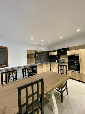 a large kitchen with a wooden table and chairs at Maison de campagne entre Ajaccio et Porticcio in Cauro