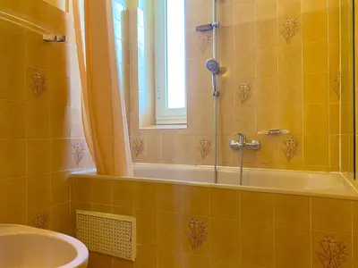 a bathroom with a tub and a sink and a window at T3 Ajaccio Sacrée Coeur in Ajaccio