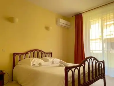 a bedroom with a bed with white sheets and a window at T3 Ajaccio Sacrée Coeur in Ajaccio