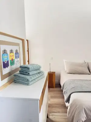 a bedroom with two beds and towels on a counter at Appartement Roi Jérôme - Hypercentre in Ajaccio