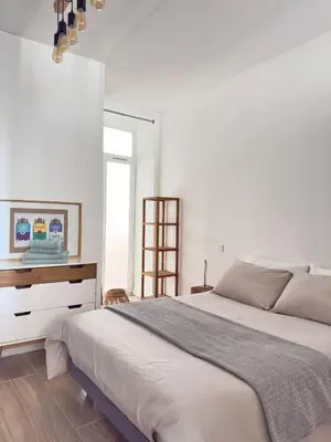 a white bedroom with a large bed and a window at Appartement Roi Jérôme - Hypercentre in Ajaccio