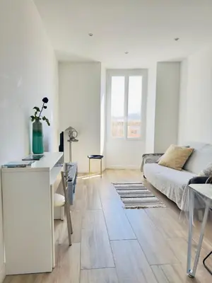 a white living room with a couch and a table at Appartement Roi Jérôme - Hypercentre in Ajaccio