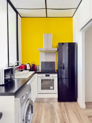 a kitchen with a black refrigerator and a washer at Appartement Roi Jérôme - Hypercentre in Ajaccio