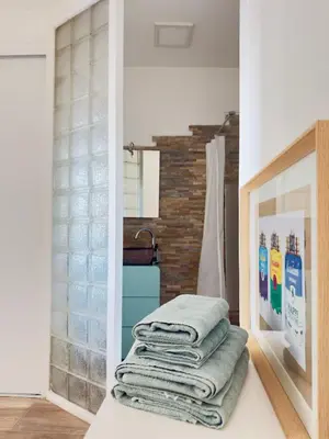 a stack of towels sitting on a counter in a bathroom at Appartement Roi Jérôme - Hypercentre in Ajaccio