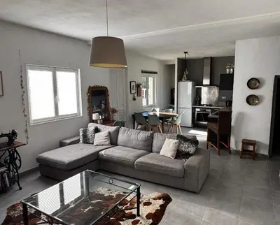 a living room with a couch and a table at Jolie maison individuelle dans l’extrême sud in Monacia-dʼAullène