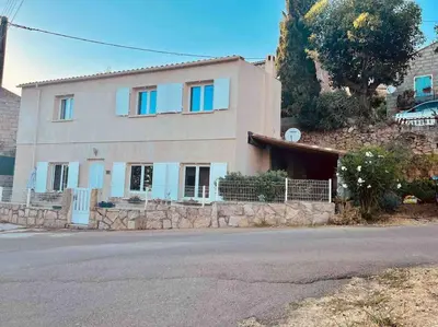 a house with blue windows on a hill at Jolie maison individuelle dans l’extrême sud in Monacia-dʼAullène