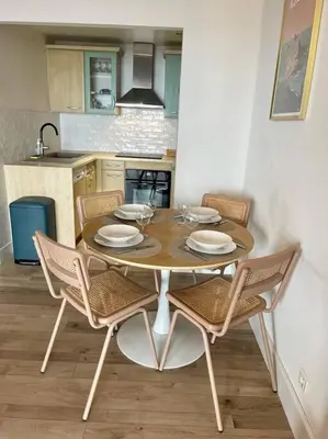 a dining room table with chairs and a kitchen at Magnifique T2 vue Mer Sanguinaires in Ajaccio