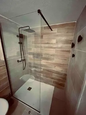 a bathroom with a glass shower with a toilet at Charmant petit appartement place de l eglise in Piana